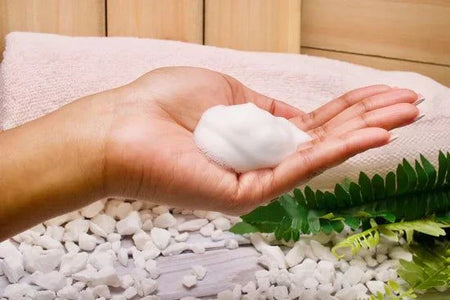 Hand holding Daily Feminine Foaming Wash with soothing, plant-derived ingredients.