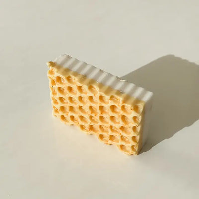 Beeswax block with honeycomb pattern on a light background