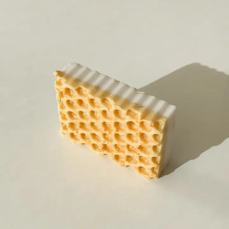 Beeswax block with honeycomb pattern on a light background