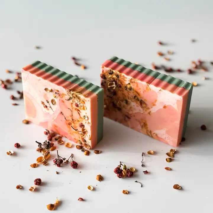 Two pink and green soap bars with a textured surface on a light background.