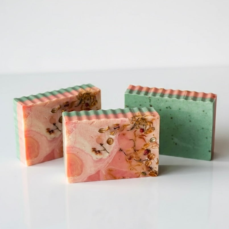 Three bars of soap with marbled designs on a white background