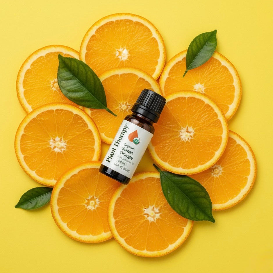 Bottle of Sweet Orange Essential Oils Citrus Blend surrounded by sliced oranges on a yellow background