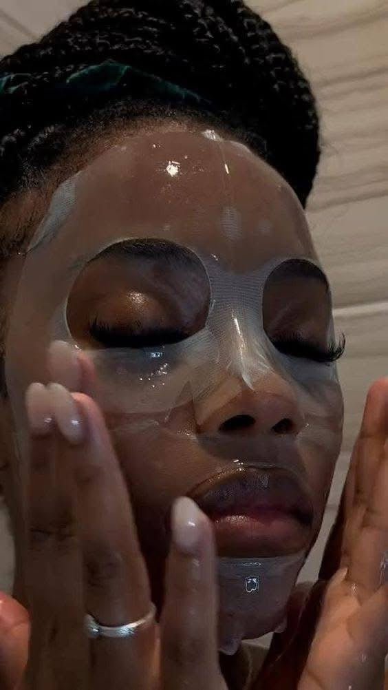 woman applying a face mask with their hands