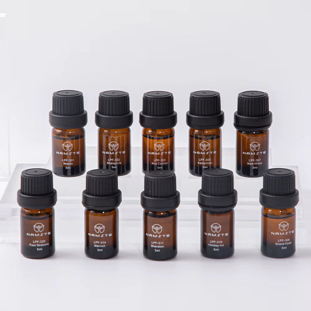 Namste essential oil set of 10 amber glass bottles with black caps, 5ml each, arranged on clear risers