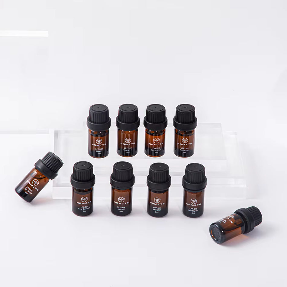Namste Essential Oil Set of 10 amber bottles with black caps arranged on clear display blocks, 5ml each, essential oil set