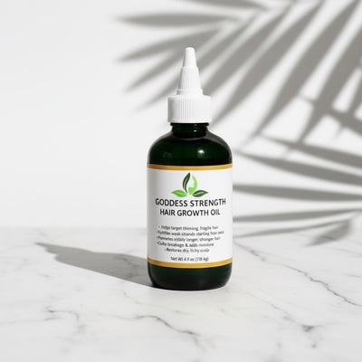 #1 bes selling hair growth - Goddess Strength Hair Growth Oil on a marble surface with leaf shadows.