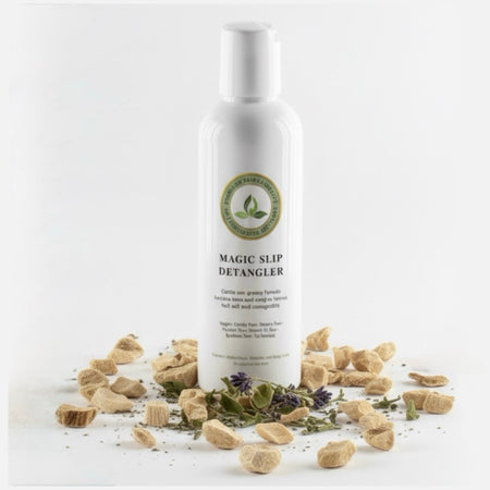 Magic Slip Detangler bottle with dried herbs on a white background